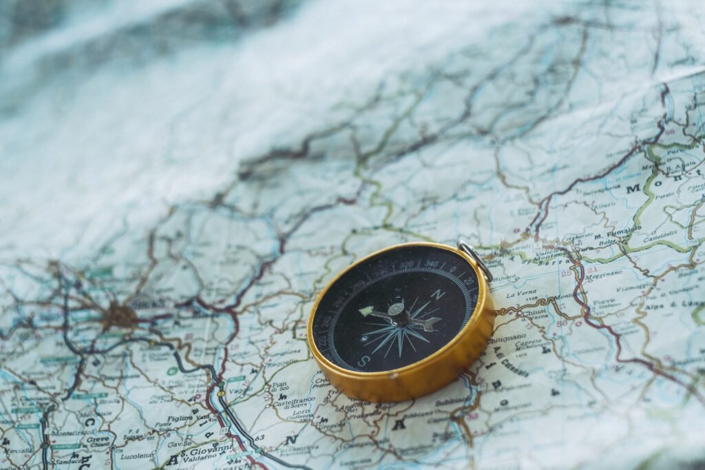Close up of compass on paper map guide. Travel and adventure lifestyle concept. Planning road