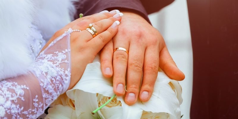Close-up Bride and grooms hands with wedding rings golden ring on finger marriage day